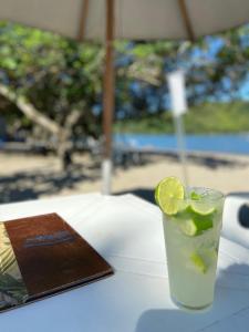a drink with a slice of lime sitting on a table at Casa da Si Hostel in Ubatuba