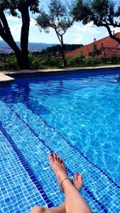 a person laying on the edge of a swimming pool at Quinta da Mata - Turismo de Habitação in Chaves