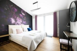 1 dormitorio con 1 cama grande y pared morada en Aparthotel Inspire Miodova Residence, en Cracovia