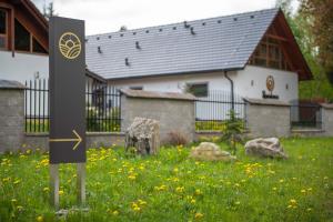 ein Schild im Gras vor einem Haus in der Unterkunft Rezidence Tři Studně in Tři Studně