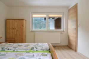 a bedroom with a bed and a window at Ferienhaus Wolf in Häselgehr