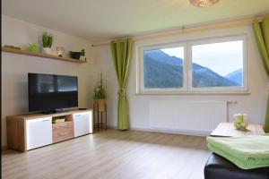 a living room with a television and a large window at Ferienhaus Wolf in Häselgehr