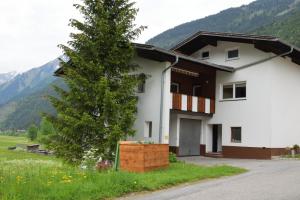 a white house with a tree in front of it at Ferienhaus Wolf in Häselgehr