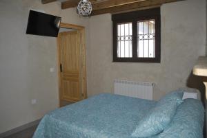 a bedroom with a blue bed and a window at CASA NATALIA, San Vitero in San Vitero