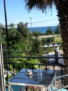 a table on a balcony with a view of the ocean at Armeno Studios in Limenaria