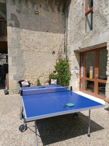 a blue ping pong table in front of a building at Le Petit Clos in Commes