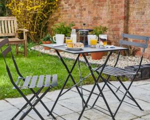 einen Picknicktisch mit einem Teller Essen und zwei Stühlen in der Unterkunft Townhouse Exeter in Exeter