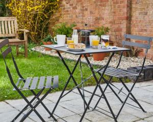 a picnic table with a plate of food and two chairs at Townhouse Exeter in Exeter