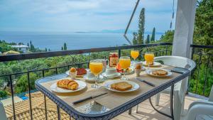 a table with food and drinks on a balcony at Apartment Zeus 2-The infinity view in Nisaki