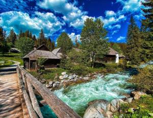 un fiume con ponte di legno accanto a una casa di Penzion Dominika a Oravský Biely Potok
