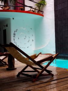 a chair sitting on a deck next to a pool at Hotel Kinbe in Playa del Carmen