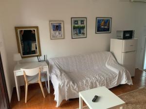Sala de estar con cama, escritorio y mesa en Apartments Natasa, en Punat