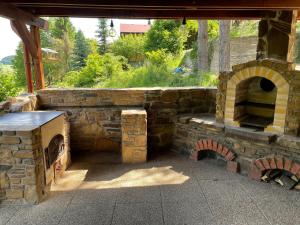 an outdoor brick oven with a stone wall at Chata Miška in Drienica