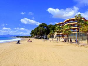 a beach with people on the sand and a building at Rentalmar Sol de España - Mas d'en Gran in Cambrils