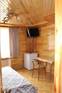 een slaapkamer met een bed, een bureau en een televisie bij Садиба "У Бервінових" in Jaremtsje