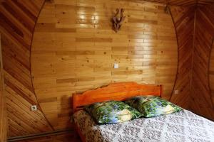 een bed in een houten kamer met twee kussens erop bij Садиба "У Бервінових" in Jaremtsje
