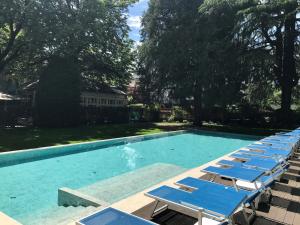 a row of blue lounge chairs in a swimming pool at Hotel Stiegl Scala in Bolzano