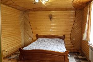 a bedroom with a bed in a wooden room at Manor "U Bervinovy" in Yaremche