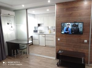 a kitchen with a tv on a wall in a room at lark apartment in Dnipro