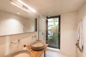 a bathroom with a sink and a large mirror at forest view villas 2 in Lagoúdi Zía