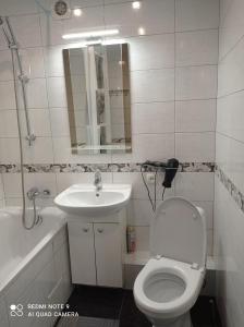 a bathroom with a white toilet and a sink at lark apartment in Dnipro