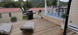 a deck with a grill and a table and chairs at 2Pines House in Jezera