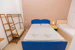 a small room with a blue bed and a ladder at Vila B&E in Vlorë