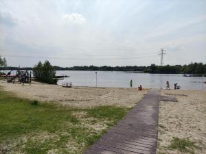 a sandy beach with people playing on the water at Dat Ankerhuus Timmel in Großefehn 