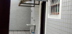 a white tiled bathroom with a sink and a window at Casa Temporada a 3 quadra da Praia in Praia Grande +12 photos