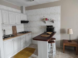 uma cozinha com armários brancos e uma bancada em Barlovento 41 em Mocanal