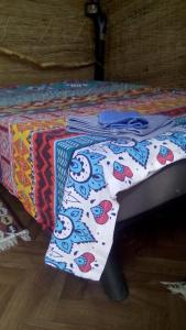 a bed with a table with a colorful blanket on it at Casa Delta 106 in Sfântu Gheorghe
