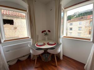 a table and chairs in a room with a window at Apartman Torre in Hvar
