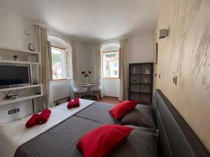 a bedroom with a large bed with red pillows on it at Apartman Torre in Hvar