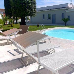 una mesa de picnic y sillas junto a una piscina en B & b Venere en Paestum