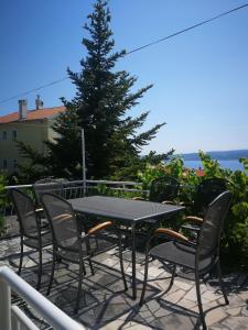 einen Tisch und Stühle auf einer Terrasse mit einem Baum in der Unterkunft Apartment Maja in Crikvenica