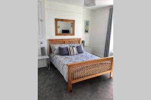 a bedroom with a wooden bed and a mirror at Large 5 bed 3 bath house 300 meters from beach and restaurants in Newquay