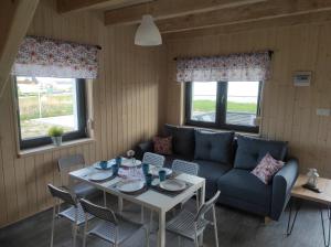 a living room with a couch and a table and chairs at Vela Sarbinowo in Sarbinowo