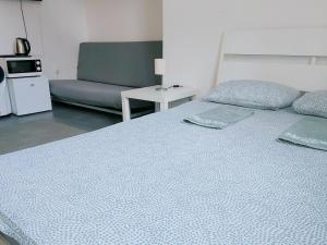 a bedroom with a bed and a couch and a table at Sleepover City Center GuestRooms in Budapest