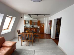 a kitchen and dining room with a table and chairs at Apartament Dwupoziomowy - klimatyzacja in Słupsk