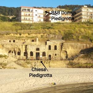 an old building on the side of a beach at B&B Domus Piedigrotta in Pizzo
