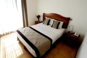 Un dormitorio con una cama grande y una ventana en Apart Versalles, en Santiago