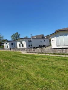 a row of houses in a yard with a fence at Holidays in Dirkshorn (Park de Horn 613) in Dirkshorn