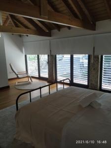 a bedroom with a large bed in a room with windows at Casa das Andorinhas in Póvoa de Lanhoso +19 photos