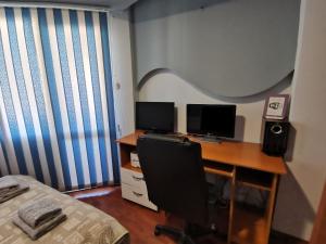 a bedroom with a desk with two computer monitors on it at Central Apartment Targovishte in Targovishte