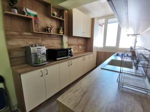 a kitchen with white cabinets and a counter top at Central Apartment Targovishte in Targovishte