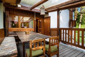 a wooden deck with a wooden table and chairs at Chata Dáša High Tatras in Mlynčeky