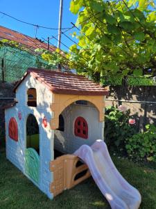 a toy play house with a slide in the grass at Besbello Suites in Santiago de Compostela