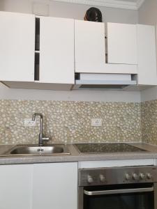 a kitchen with white cabinets and a sink at Villa 27 Residence in Tirana