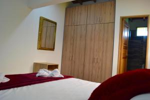 a bedroom with a bed and a wooden cabinet at Roble Colonial - Apartamentos Deluxe en Guatapé in Guatapé +49 photos