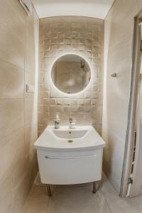 La salle de bains est pourvue d'un lavabo blanc et d'un miroir. dans l'établissement Villa MARIKA plus, à Alajõe